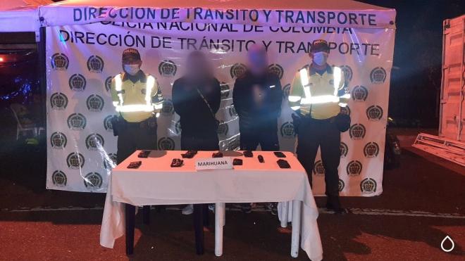 dos personas capturadas-policías custodiando-alucinógeno incautado