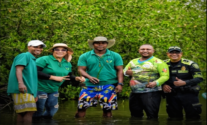Funcionarios y asistentes participan en actividades de restauración y protección de los ecosistemas costeros mediante la siembra de mangle.
