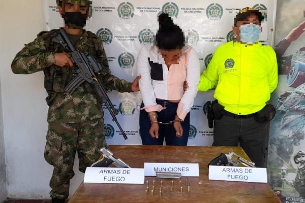 una mujer capturada-soldado y policía custodiando-armas de fuego