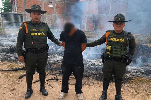 Dos polic&iacute;as custodian a un hombre capturado