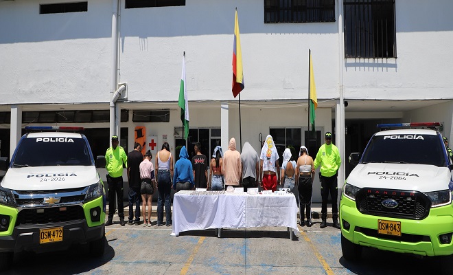Polic&iacute;as custodian personas capturadas en la mesa material incautado, estupefacientes, dinero y arma de fuego 