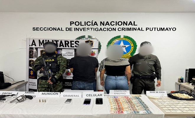 Policías, Ejército presentan a dos personas capturadas y frente a ellos una mesa con los elementos probatorios incautados