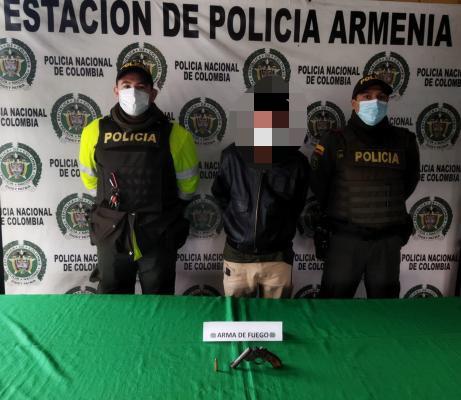 una persona capturada-policías custodiando-arma de fuego incautada