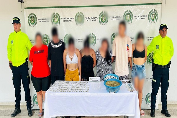 Dos funcionarios de la SIJIN, 8 personas capturadas, mesa con estupefacientes