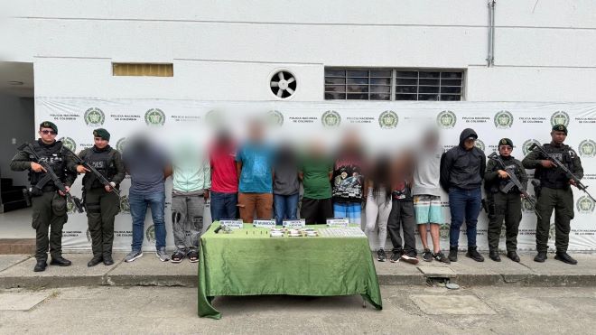 policía nacional al lado de diez personas capturadas por homicidio