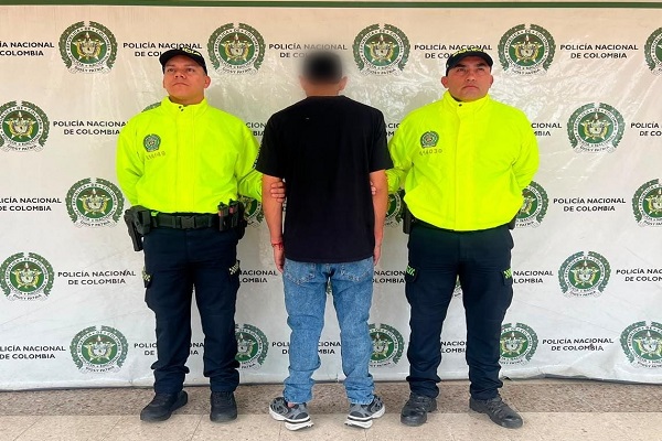 Dos policías custodian a un hombre capturado por orden judicial