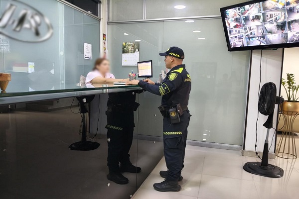Policía con ciudadana realizando control en el sector hotelero