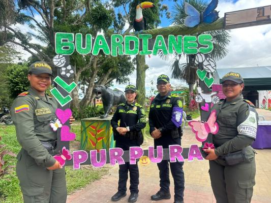 Oficiales de policía con sus distintivos, frente al mismo arco temático, resaltando su labor de protección y servicio a la comunidad en la región amazónica
