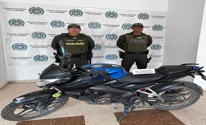 Dos uniformados de la Polic&iacute;a con una motocicleta recuperada 