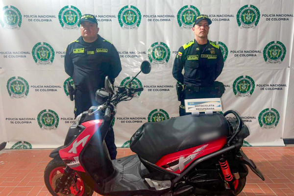 Dos Policías, en frente motocicleta recuperada 