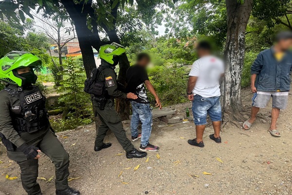 Policías realiza registro a persona a ciudadano y otro policía presta la seguridad durante el procedimiento