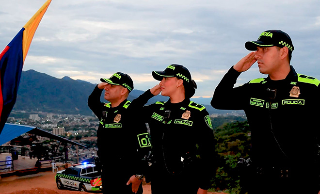 Tres oficiales en saludo a la bandera.