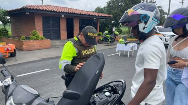 un polic&iacute;a realizando registro a dos ciudadanos