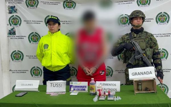 un policía y un soldado del ejército al lado de un capturado